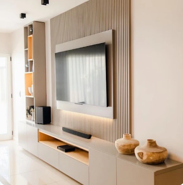 A refined media wall with natural texture, integrated storage and subtle lighting